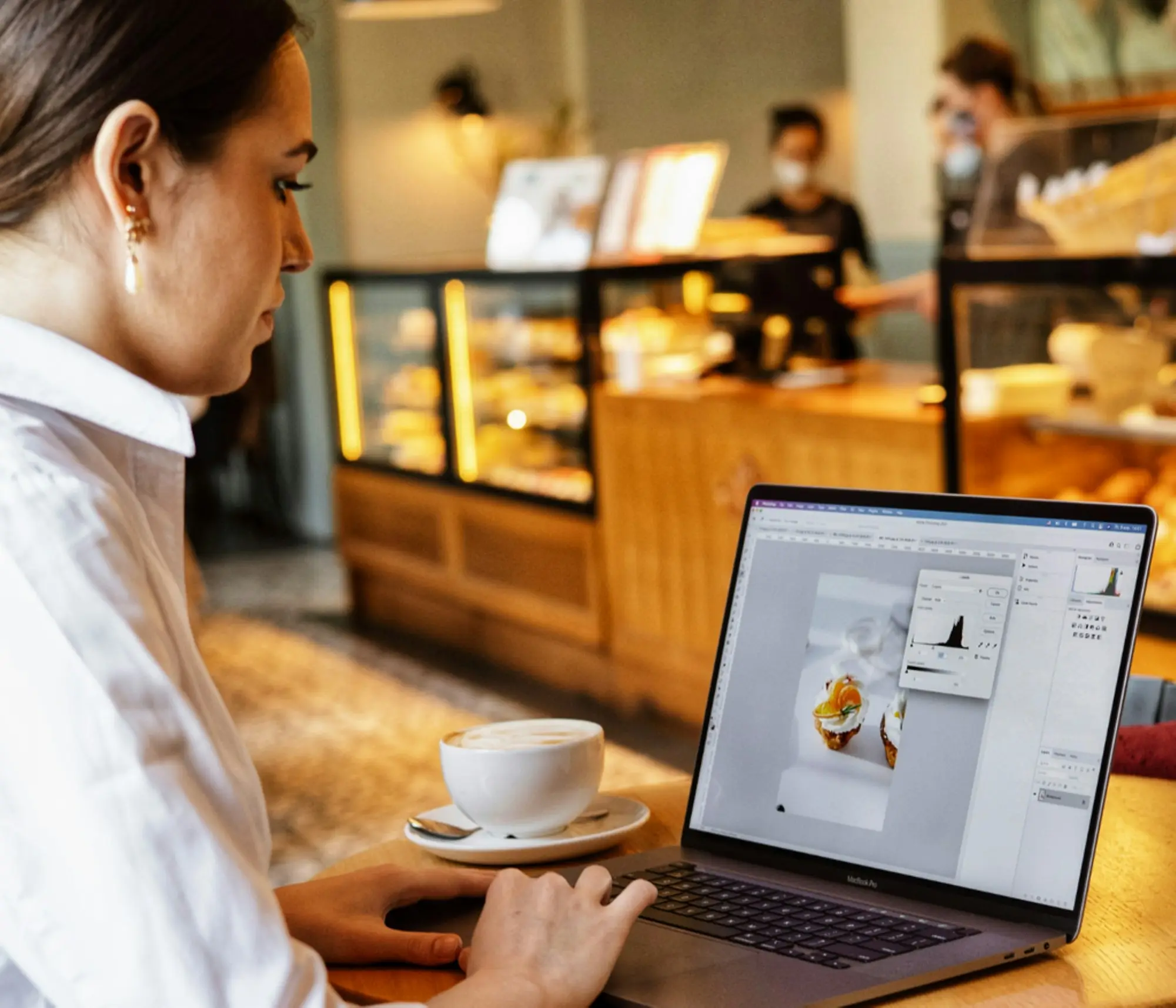Business owner reviewing figures on a laptop in her bakery