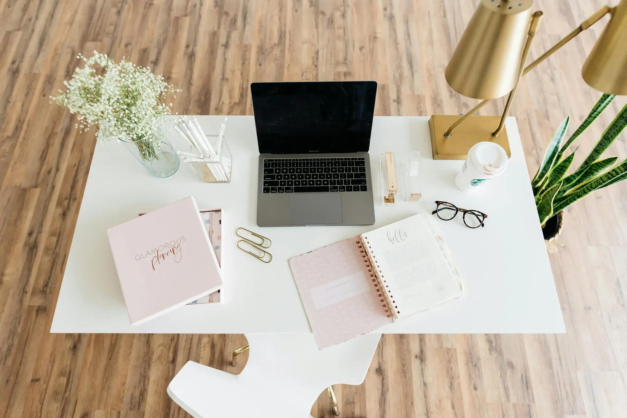 Tidy desk with a laptop, documents folder and notes