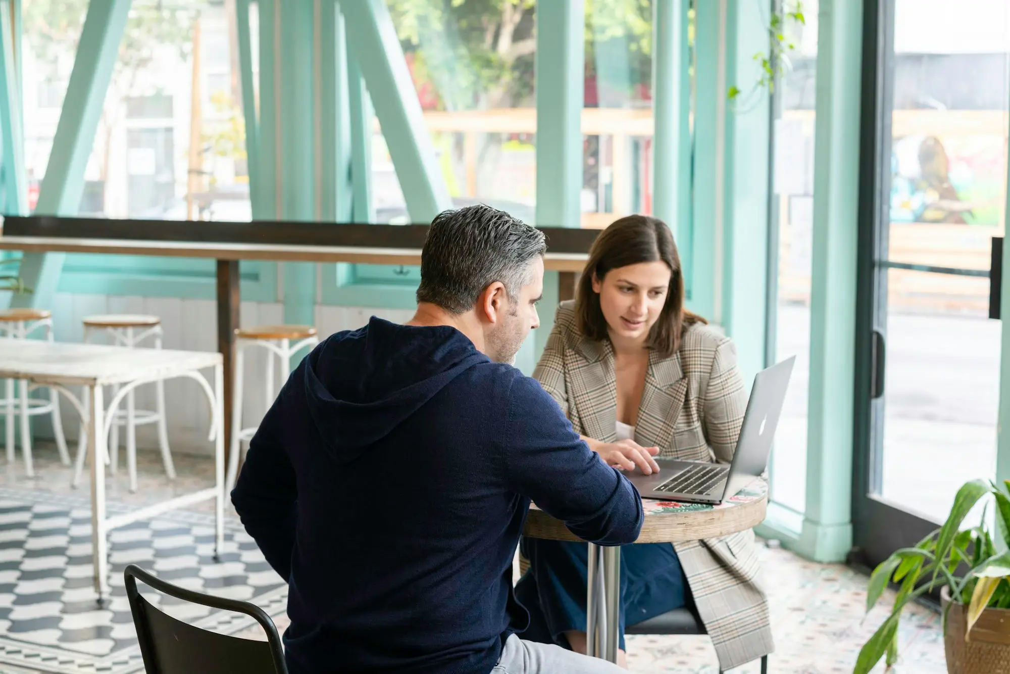 Business owner meeting her accountant at a cafe table