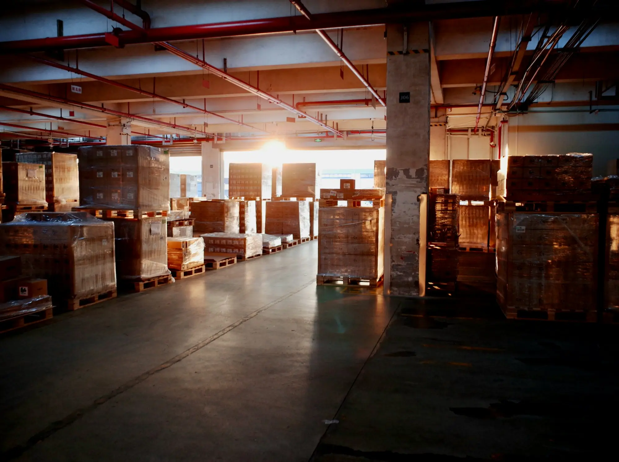 Warehouse aisles stacked with pallets in the afternoon light
